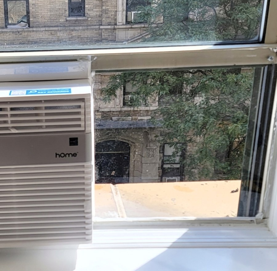 Plexiglass side panel beside a window AC